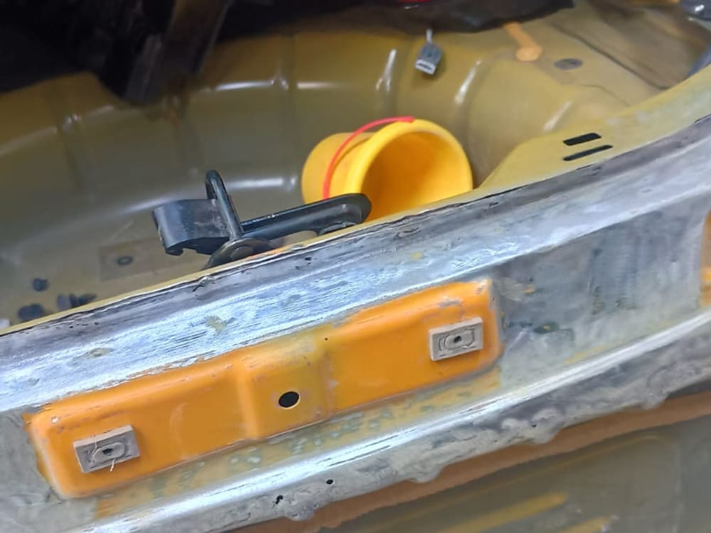 Paragolpes trasero en metal desnudo, preparado tras un trabajo de desabolladura