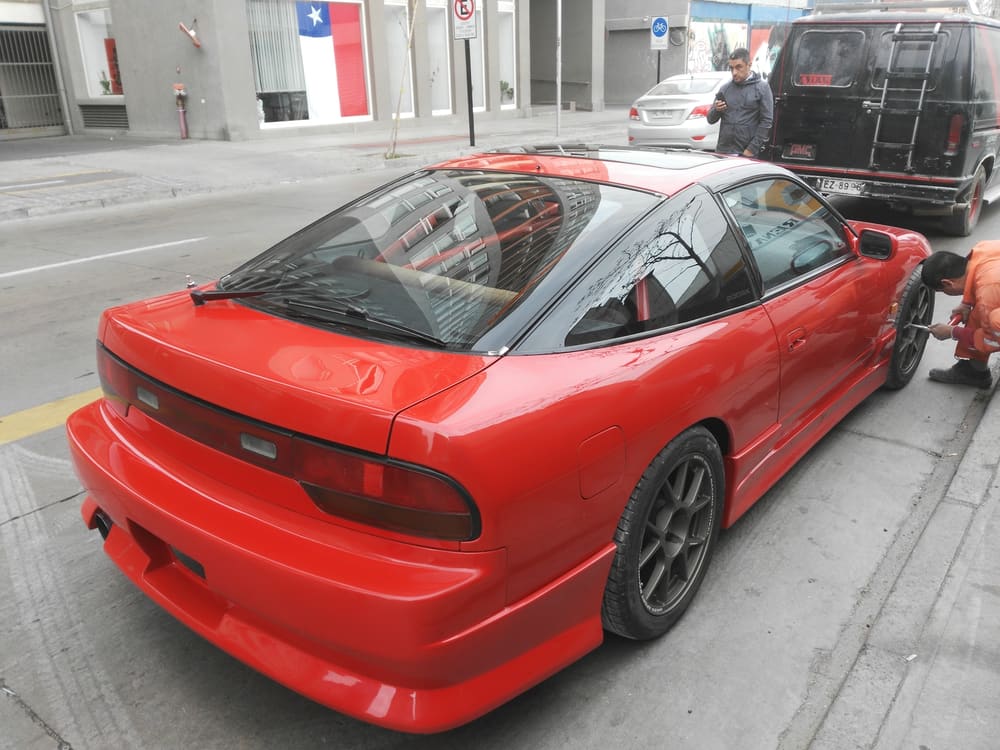 Nissan 200SX rojo recibiendo mantención en el taller