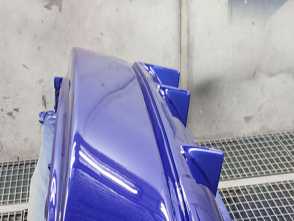 Pieza recién salida de la cabina de pintura al horno, terminación azul